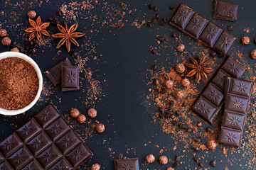 Frame of chocolate bar and pieces with spice ingredients for cooking dessert
