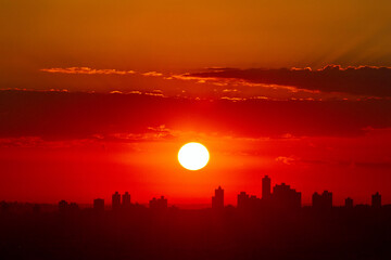 Naklejka premium Sunrise in the city with flare and clouds
