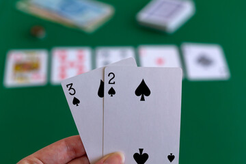 royal flush in hand.hands hold two black cards in game in casino. playing cards with blue deck on the green table. combination of cards on a green casino desk background with copy space.