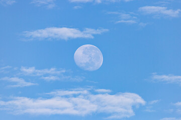 Naklejka na ściany i meble Moon in the day with clouds in the blue sky