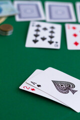 playing cards and chips.two of diamond and spade ace in casino. playing cards with blue deck on the green table. combination of cards on a green casino desk background.copy space. vertical