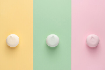 Colorful marshmallows on three different colors backgrounds (yellow, green, pink). Top view, flat lay, copy space. Trendy multi color round zephyr (zephir).