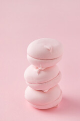 Stack of round pink marshmallows on pastel pink background, close-up. Three sweet zephyr candies for postcard.