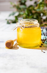Flowing honey from wooden dipper in a glass jar. Organic honey dipping from the wooden honey spoon. Lavender honey