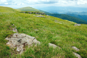 stones on the hill of mountain meadow. beautiful summer landscape with clouds above the horizon