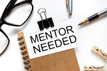 Mentor Needed. the inscription on the business card is attached to the notebook.