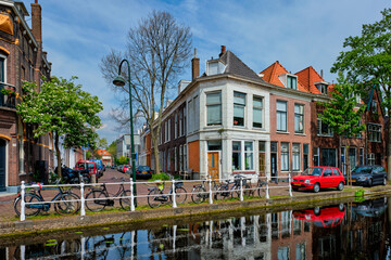 Cars on canal embankment in street of Delft. Delft, Netherlands