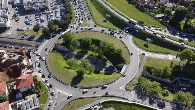 Aerial shot of a large roundabout, the traffic travels through the city roads