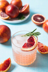 Blood orange paloma cocktail on blue table background. Summer cocktails, lemonade, refreshing drinks, cocktail party concept.