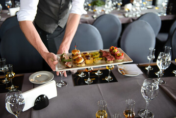 Man serving snacks to pair with whiskey taste. Whiskey and food pairing.