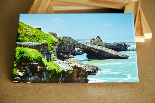 Photo canvas print stretched with gallery wrap and wooden stretcher bars on fiberboard table, landscape photo