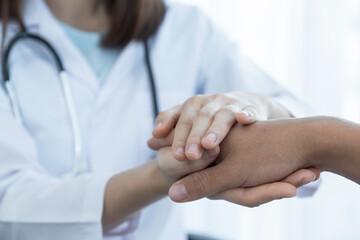 The doctor hands holding patient hand to encouragement and explained the health examination results