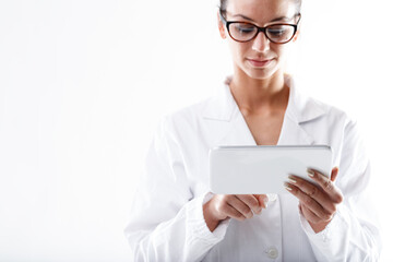 Serious doctor or nurse wearing glasses using a tablet pc