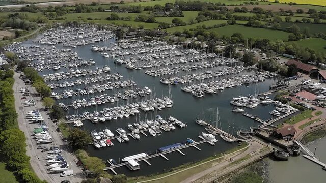 Aerial footage of Yachts and Boats on pontoons at Chichester Marina a popular sailing destination in the beautiful countryside of West Sussex in Southern England.