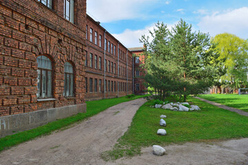 Garden with stones and trees in the yard of an old brick building