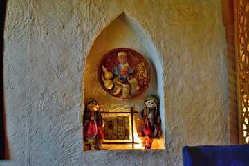 Installation of oriental doll in niche in the wall