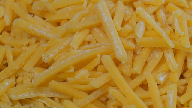 Overhead slider shot of grated cheddar cheese in a mound