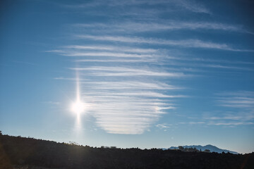 nubes cirrus junto al sol en un cielo azúl