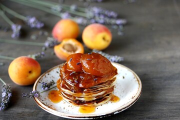 pancakes with jam slices of apricot with lavender. copy space, space for text