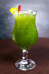cold green cocktail with ice and lemon in the cafe