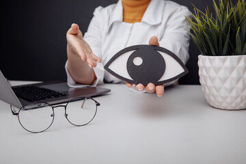 Doctor showing a wooden eye. Healthcare idea
