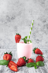 A glass of milk shake and fresh strawberries