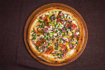 pizza with flask, tomatoes and green onions view from top