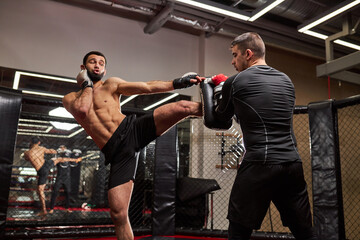 Naklejka premium MMA. Two young professional boxers boxing, athletes fighting. Sport, competition, excitement and human emotions concept. Copy space, Sport concept