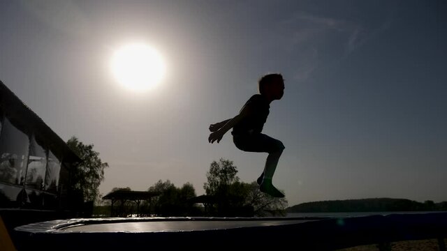 baby boy jumping having fun on a trampoline standing on the street