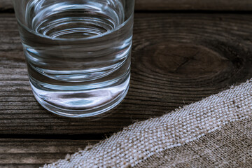 Shot of vodka with piece of cloth on an old wooden table. Close up view