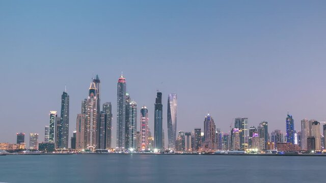 Dubai Marina skyline with JBR day to night transition timelapse panorama as seen from Palm Jumeirah in Dubai, UAE. This part of Dubai has more skyscrapers over 50 stories