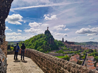 Pilgrims looking at the magnificent view over Le Puy en Velay, departure of the camino de santiago. France. 