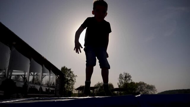 baby boy jumping having fun on a trampoline standing on the street