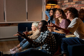 Young cheering friends or basketball fans watching basketball game on tv at home.Friendship, sports and entertainment concept. Young people worry about favourite team