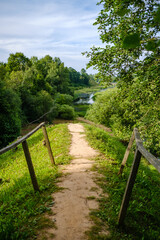 Fototapeta premium narrow countryside forest road with gravel surface