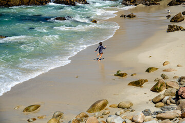 A child runs along the coast of the ocean