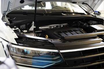 On a modern car, the hood is open and the engine is visible. Car repairs, repairs and spare parts.