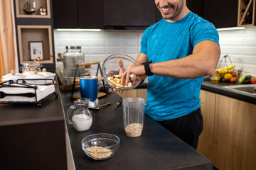Tasty fruit shake incoming, young man preparing himself a tasty treat in the kitchen