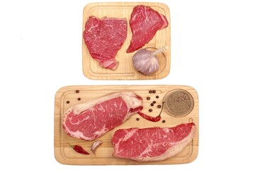 Pepper and Striploin Beef Steaks on Wooden Board Isolated On White Background. Raw Sirloin Beef or Veal Steaks White Isolated, Top View. Tenderloin Beef Steaks On Wood, Overhead View.