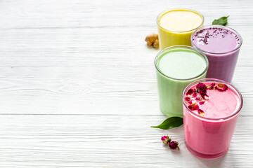 Green, yellow and pink latte. Hot colorful coffee or tea with milk