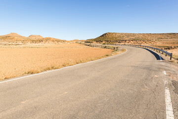 a paved road on a desert dry landscape next to Monreal de Ariza, province of Zaragoza, Aragon, Spain
