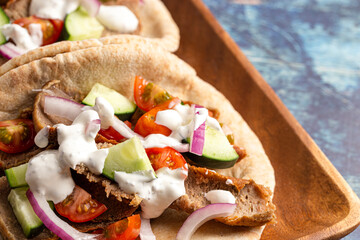 Gyros with Vegetables and White Garlic Sauce on a Rustic Wooden Table