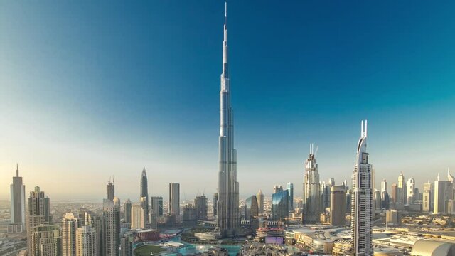 Dubai Downtown evening timelapse with Burj Khalifa and other towers paniramic view from the top in Dubai, United Arab Emirates. Shadows moves very fast. Traffic on circle road and fountains