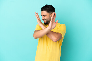Young arab man isolated on blue background nervous stretching hands to the front