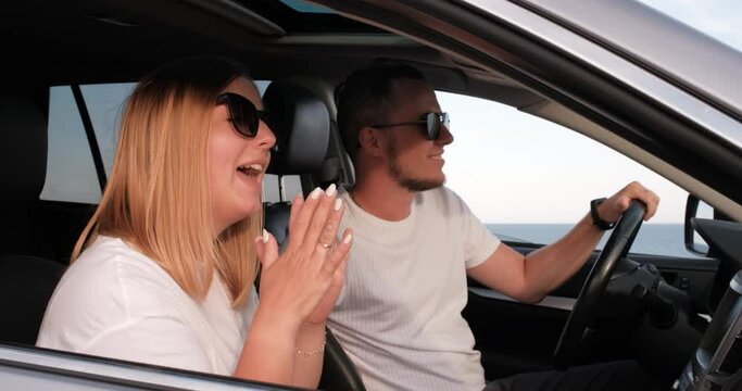 Young Man and Woman Having Fun in Car with Sea View from Window, Travel and Roadtrip in Summertime