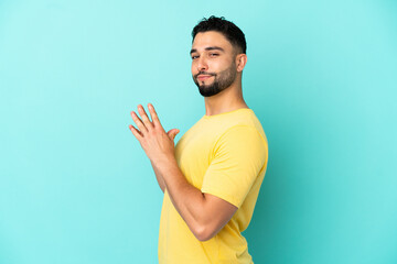 Young arab man isolated on blue background scheming something