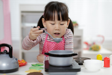 young  girl pretend play food preparing at home