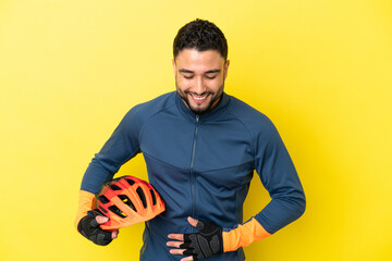 Young cyclist arab man isolated on yellow background smiling a lot