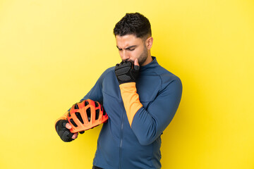 Young cyclist arab man isolated on yellow background having doubts