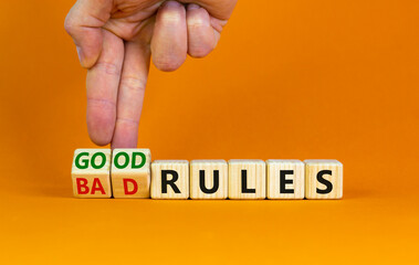 Good or bad rules symbol. Businessman turns wooden cubes and changes words 'bad rules' to 'good rules'. Beautiful orange table, orange background, copy space. Business and good or bad rules concept.